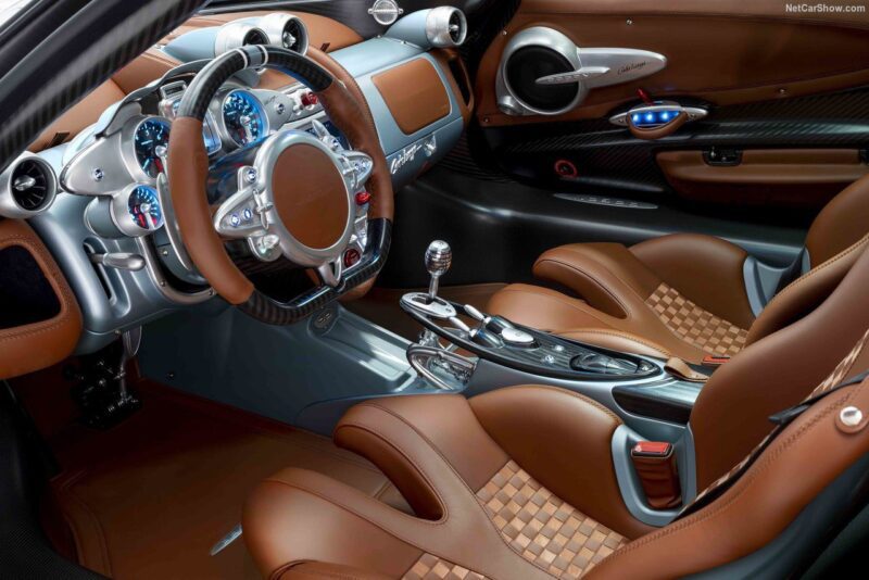 Brown and tan leather interior of a luxury sports car, featuring metal accents and an array of dials—similar to the craftsmanship Pagani will showcase with four hypercar icons at the upcoming 9th Historic Minardi Day in Imola.
