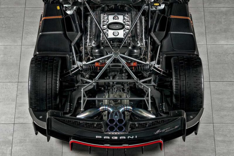 Overhead view of a Pagani Huayra’s exposed engine and rear suspension, showcasing detailed mechanical parts and twin exhaust pipes. Pagani to showcase four hypercar icons at the upcoming 9th Historic Minardi Day in Imola.
