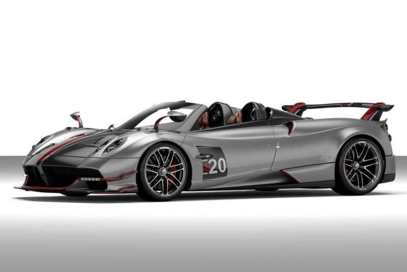 A silver and black convertible sports car with red accents, the number 20 on the door, and a large rear wing, reminiscent of vehicles Pagani will showcase at the upcoming 9th Historic Minardi Day in Imola. Displayed in a studio setting.