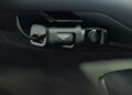 Close-up of a Bentley dashcam mounted behind a car's rearview mirror, displaying the Bentley logo and visible cable—an ideal addition for those who appreciate luxury features like the Bentayga pet range and other Bentley pet accessories.