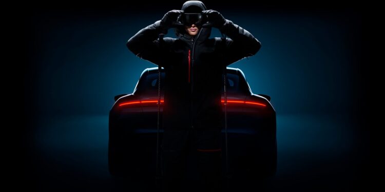 A person in dark clothing and a helmet stands in front of a Porsche sports car with illuminated rear lights, set against a dark background.