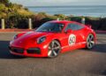 A red Porsche sports car with the number 60 and "Porsche" on the side is parked near a coastal road with ocean views—just one of many stunning Porsches for sale at Porsche San Luis Obispo.