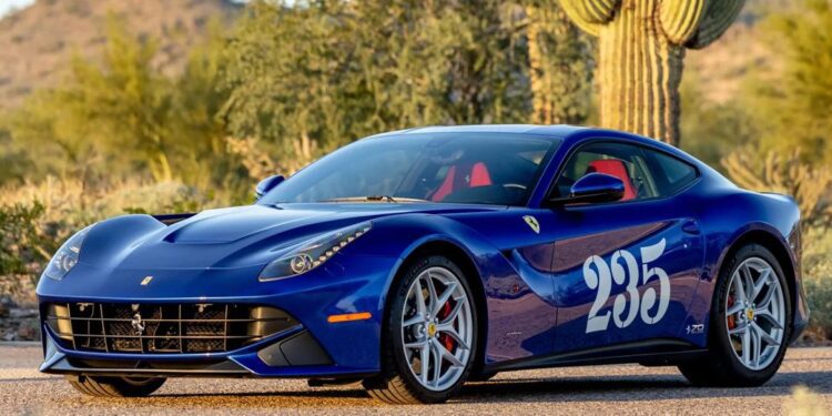 A blue Ferrari F12berlinetta, a true example of Ferrari supercars, with the number 235 on the door, is parked on a road in a desert landscape surrounded by cacti and mountains.
