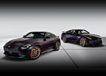 Two black Nissan sports cars with gold rims, featuring 300ZX-Inspired Design cues, are parked on a white surface in a studio setting.