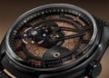 Close-up of a limited edition Ulysse Nardin wristwatch with exposed gears, copper-toned textured dial, and skeletonized hands inside a black case.