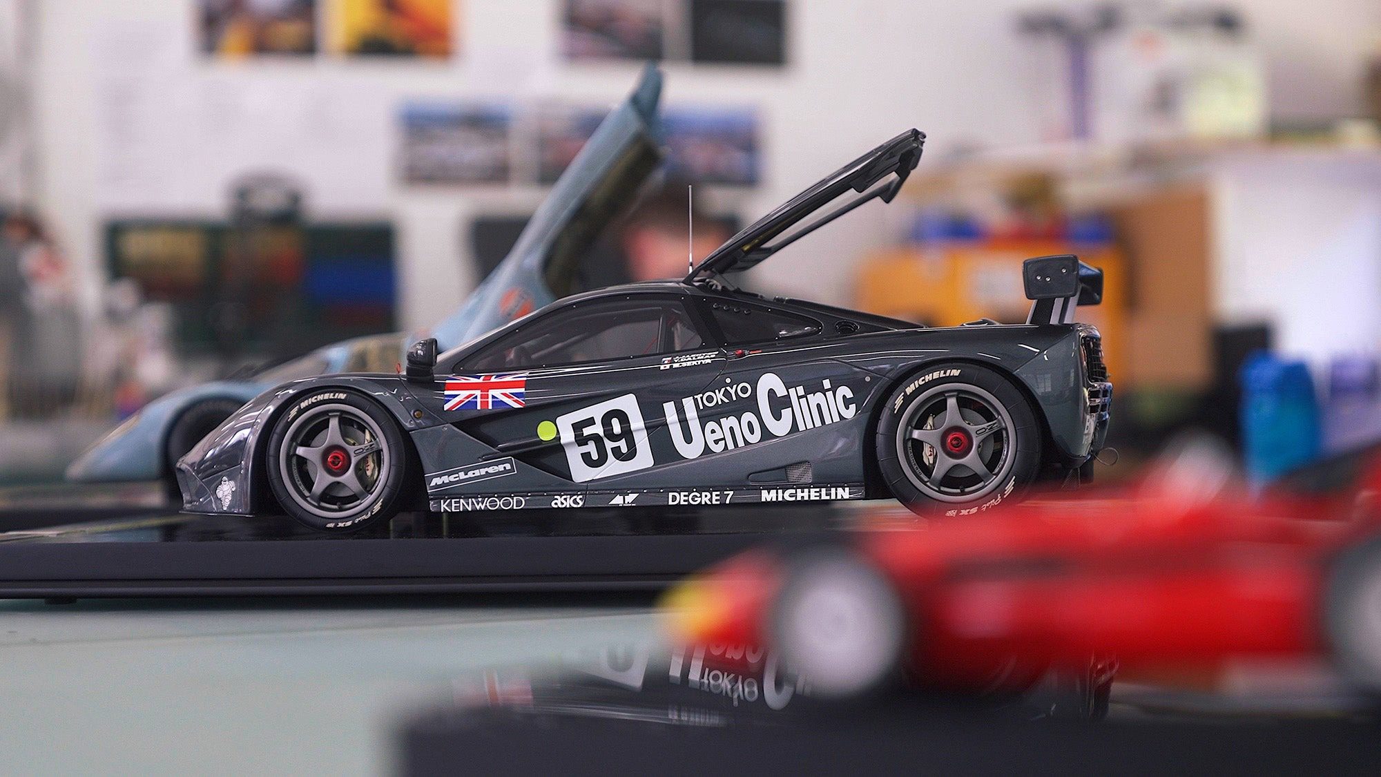 A detailed model from the Amalgam Collection, this racing car with number 59 and "Ueno Clinic" branding is displayed with its rear hood open on a tabletop, embodying true Miniature Legacy.