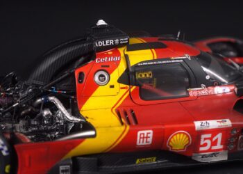 Close-up view of a red and yellow Ferrari race car from the Amalgam Collection, highlighting the cockpit, exposed engine components, and number 51 on the door.