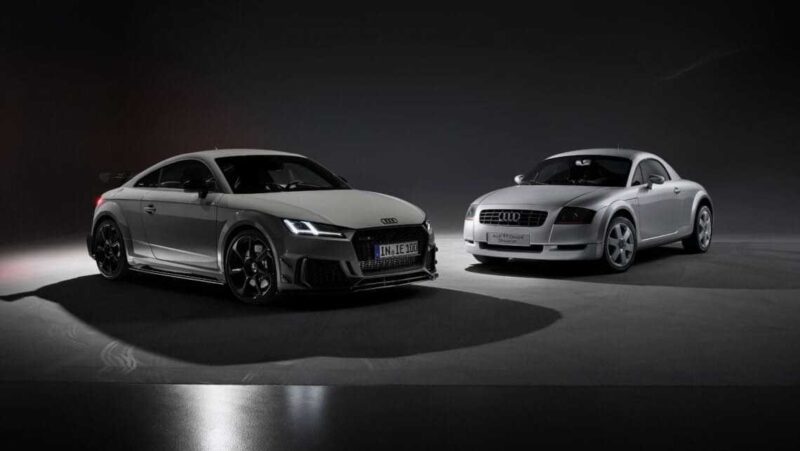 Two Audi TT sports cars, one modern and one older model, are parked side by side in a dimly lit studio setting, illustrating the legacy of the TT as anticipation grows for its Audi TT successor and possible flagship EV.