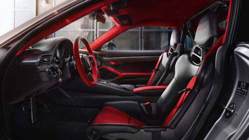 Interior of a modern 991 Porsche 911 GT2 RS with black and red leather seats, a red steering wheel, and detailed dashboard controls—a setup whose value is skyrocketing among sports car enthusiasts.