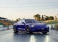 A blue Porsche Taycan Turbo GT is parked on the Sydney Dragway, poised to chase a quarter-mile record, with empty stands and green grass in the background.