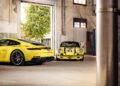 Two yellow Porsche 911 sports cars, including a legendary Porsche 911 S/T, are parked inside an industrial-style garage with large windows and exposed pipes.
