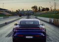 A Porsche Taycan Turbo GT with the license plate "FOH:87V" is positioned on the Sydney Dragway at sunset, facing the starting line, ready to chase a new quarter-mile record.