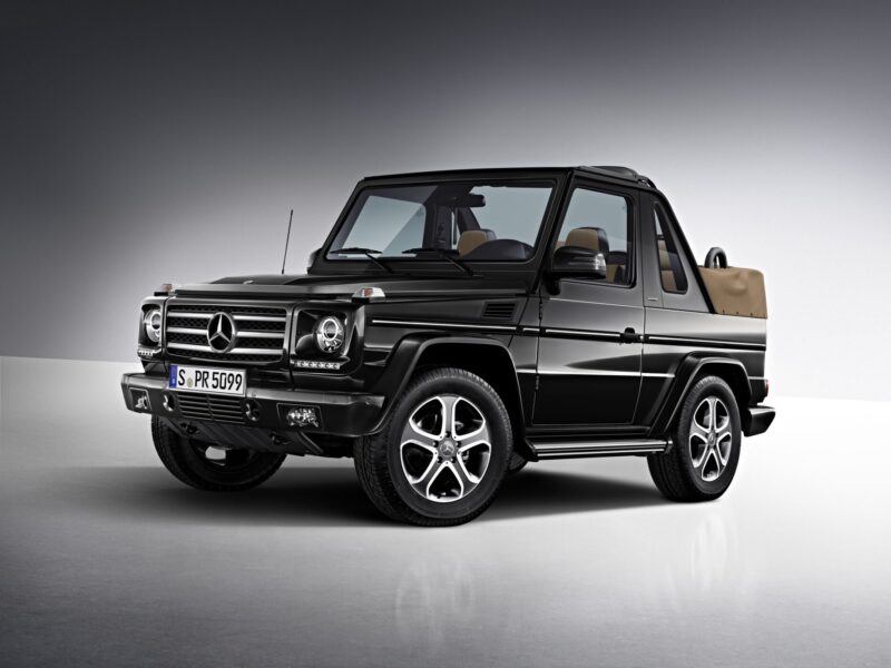 A black Mercedes-Benz G-Class convertible SUV, inspired by the teased G-Class Cabriolet revival with four doors instead of two, is parked in a studio setting with a gray gradient background.