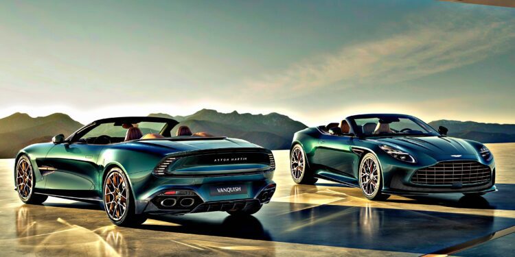 Two green Aston Martin Vanquish convertibles, part of the Q by Aston Martin Marks 60 Years of Volante with Ultra-Exclusive Anniversary Editions, are parked on a sleek terrace with mountains behind and sunlight glinting off their curves.
