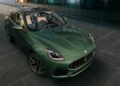 A green Maserati Grecale Folgore SUV, showcasing advanced EV tech, is parked on a paved surface near a modern glass building, viewed from a high front angle.