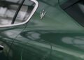 Close-up of a green Maserati Grecale Folgore's rear side, featuring the silver trident emblem above the fuel door, with EV Tech reflections shimmering on the surface.