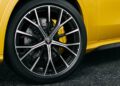 Close-up of a black alloy wheel with Maserati emblem, ventilated brake disc, and yellow brake caliper on a yellow Grecale Folgore EV parked on asphalt.