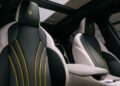 Luxury car interior with black and white leather seats featuring yellow accents and the Maserati logo, advanced EV Tech, and a panoramic sunroof visible above—crafted for the all-electric Grecale Folgore.