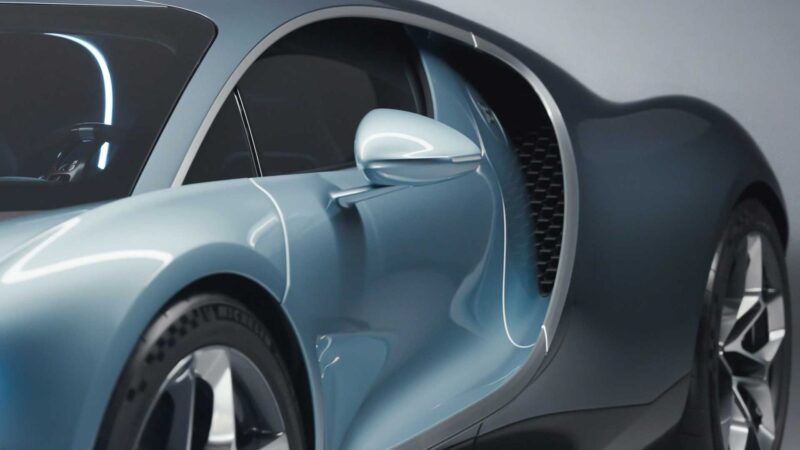 Close-up view of the side of a sleek, modern blue sports car, highlighting the door and aerodynamic curves—showcasing how form, function, past and the future came together in the Bugatti Tourbillon.
