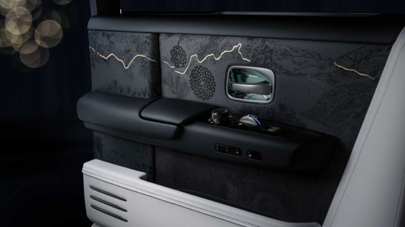 Close-up of a luxury car door interior featuring embroidered detailing, ambient lighting, and sleek control buttons—part of the Rolls-Royce Honors 100 Years Of Phantom With Groundbreaking Private Collection.