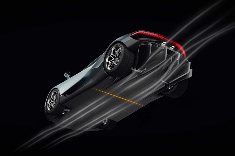 A low-angle view of a Bugatti Tourbillon sports car with aerodynamic airflow lines illustrating air movement over and under the vehicle against a black background.