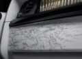 Close-up of a car interior door panel, as the Rolls-Royce Honors 100 Years Of Phantom With Groundbreaking Private Collection, featuring a detailed line drawing of a building complex and surrounding landscape.