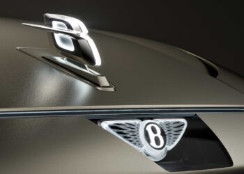 Close-up of a Bentley car hood, featuring the illuminated emblem and hood ornament—hinting at Bentley to reveal more about its upcoming EV and a limited-run model coming before year-end.