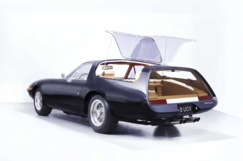 A classic black sports car, 1-of-1: Rarest Ferraris In The World, with its rear hatch open reveals a beige interior and luggage space, beautifully photographed on a white background.