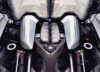 Close-up view of a Porsche engine bay, featuring two large silver air intake covers and visible suspension components—an impressive sight among the 10 Production Cars That Pack a V10 Engine.