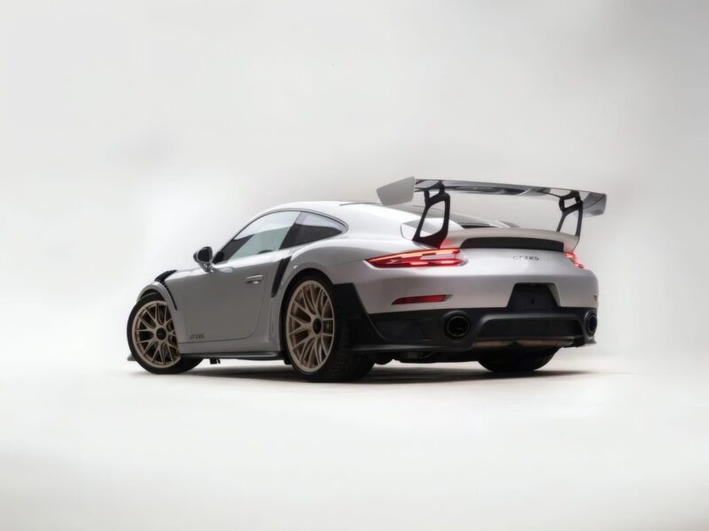 For Sale: 2018 Porsche 911 GT2 RS, the last of its kind before electrification, is showcased in a studio with a large rear wing and beige wheels against a plain white background.