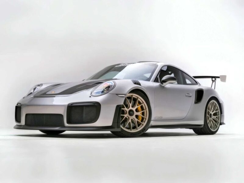 For Sale: 2018 Porsche 911 GT2 RS—last of its kind before electrification. This silver sports car features black accents and a large rear wing, beautifully photographed in a studio with a white background.
