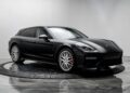 A black Porsche Panamera Sport Turismo wagon, part of the Luxury Performance Wagons category, is displayed in a modern showroom with a white background and reflective floor.