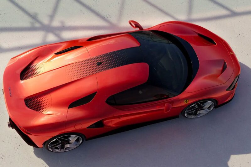 Aerial view of a red sports car with black detailing on a light-colored surface; shadows of a structure are visible on the ground, highlighting this 1-of-1: Rarest Ferraris In The World.