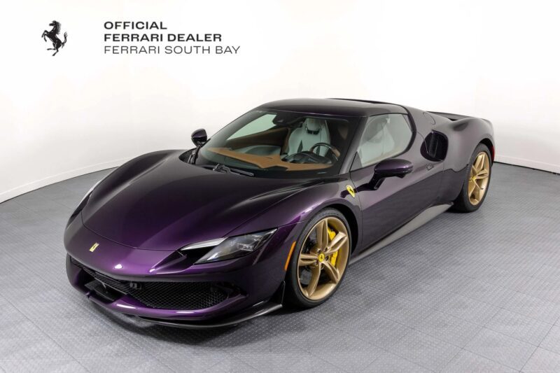 A purple Ferrari sports car with gold wheels is displayed in a showroom, highlighting unique Ferrari colors and featuring Ferrari South Bay dealership branding on the wall.