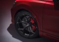 Close-up view of a red Audi’s front wheel with a black rim, visible brake disc, and red brake caliper—showcasing details highlighted in the Review: 2025 Audi RS Q8 Performance.