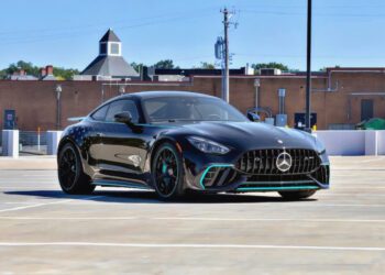 A black Mercedes-Benz AMG GT 63 PRO parked in an empty outdoor parking lot with a brick building in the background, this Collectors Edition is now available for sale.