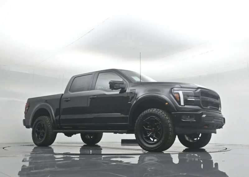 A black pickup truck with large tires is parked in a brightly lit, white studio setting, showcasing the style and comfort that define today’s luxury trucks.