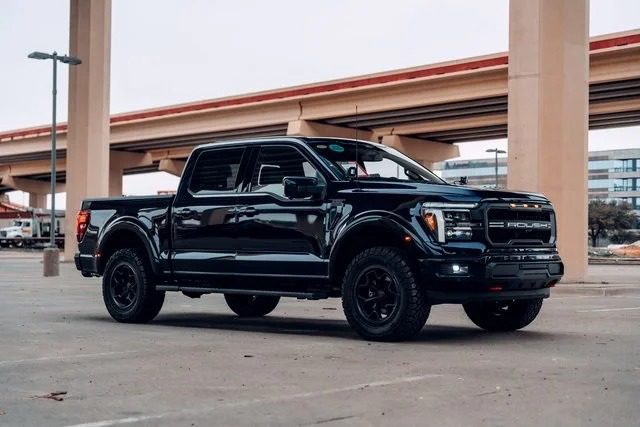 A black luxury truck with four doors is parked in an empty lot under an overpass, blending comfort and capability in its sleek design.