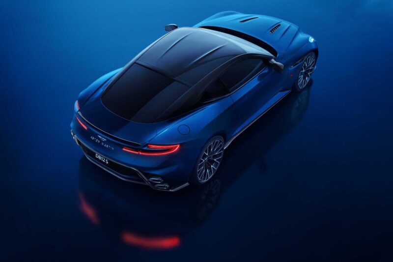 A blue Aston Martin DB12 S sports car photographed from above on a glossy blue surface, showcasing its sleek design, rear lights, and aerodynamic features—an icon among Super Tourers.