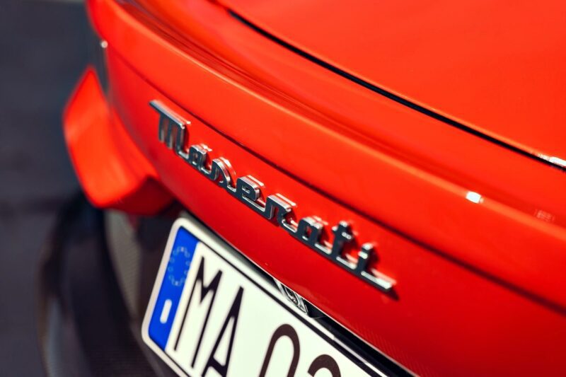 Close-up of the rear of a red Maserati car, showcasing the Maserati emblem and part of a license plate starting with "MA," as seen in the 2026 Maserati MC Pura Cielo First Drive.