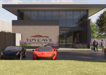Modern building with large windows labeled "TOYCAVE," three sports cars parked in front, and several people walking toward the entrance on a sunny day.