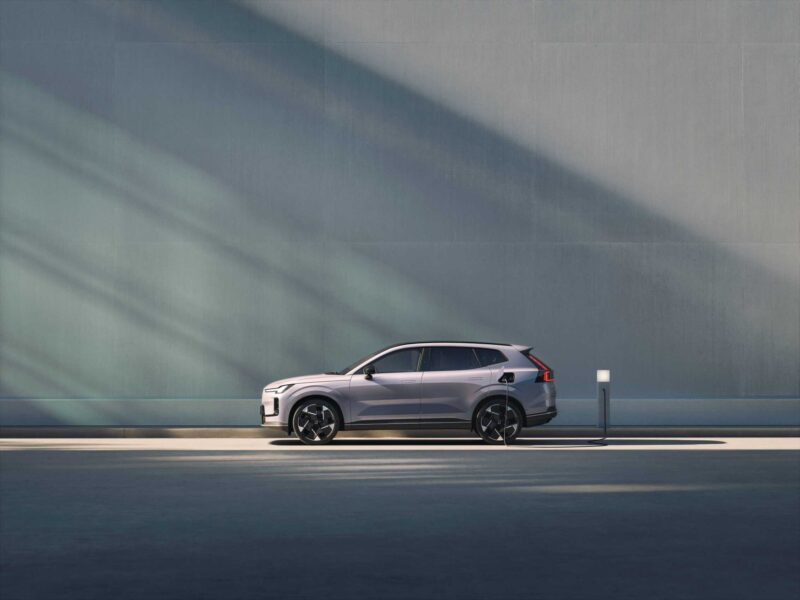 A silver SUV is parked beside a modern gray wall with sunlight casting diagonal shadows across the scene—a testament to Volvo’s global plug-in hybrid sales crossing one million.