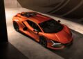 An orange Lamborghini sports car is parked indoors under dramatic lighting, its sharp lines and aerodynamic design reflecting the innovation of Lamborghini Centro Stile at 20: The Studio Behind Every Modern Bull.