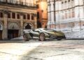 A green Lamborghini sports car, crafted with the vision of Lamborghini Centro Stile at 20: The Studio Behind Every Modern Bull, is parked on cobblestone in front of historic buildings with arched windows and ornate architecture.