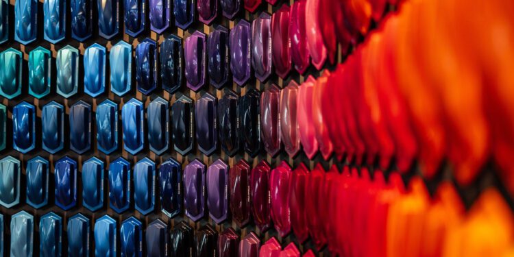 A wall displays an array of car paint samples arranged in hexagonal patterns, featuring a gradient of colors from blue and purple on the left to red and orange on the right—highlighting the origins of iconic Lamborghini colors.