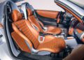 Luxury sports car interior featuring tan quilted leather seats, metallic trim, and a sleek dashboard with modern controls—reminiscent of the exclusivity found in a Pagani Huayra Codalunga at the Las Vegas Concours.