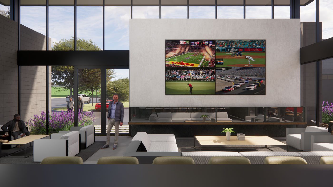 A modern lounge with large windows, white sofas, a man standing, and a wall-mounted TV displaying multiple sports events.