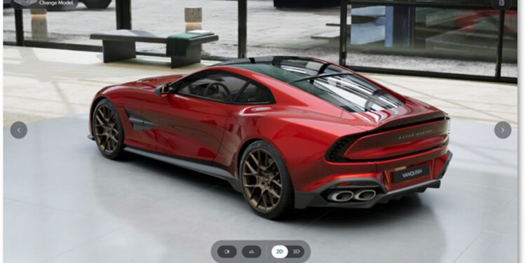 A red Aston Martin sports car with bronze alloy wheels is parked indoors on a concrete floor near large windows, capturing the refined look you can create with the Aston Martin online configurator.