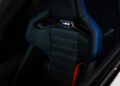 Black car seat with blue and red stitching, featuring an illuminated "M2" logo on the headrest—crafted for the BMW 2026 M2 Turbo Design Edition, inspired by the 2002 Turbo Legacy.