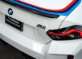 Close-up of the rear of a white BMW M2 Turbo Design Edition with "M2" and "turbo" badges, distinctive tail lights, and the BMW logo—echoing the spirit of the iconic BMW 2002 Turbo.